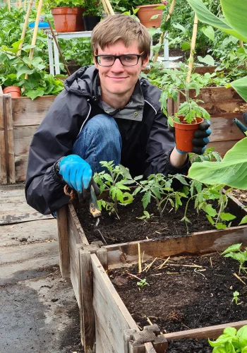 farm helper planting in raised beds